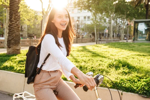 屋外公園の通りに自転車の上を歩く若いきれいな女性の写真 — ストック写真