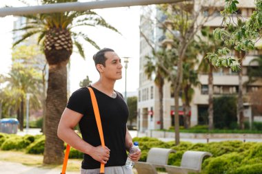 Açık havada su şişe ile yürüyen adam yakışıklı genç güçlü görüntü spor.