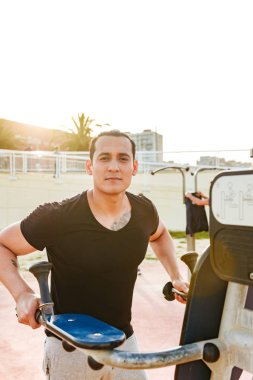 Fotoğraf konsantre yakışıklı genç güçlü adam açık havada yapmak egzersizleri spor.