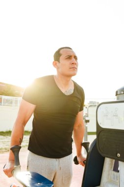 Fotoğraf konsantre yakışıklı genç güçlü adam açık havada yapmak egzersizleri spor.