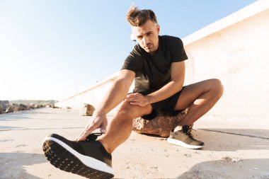 Sabah deniz kenarında germe egzersizleri yapıyor çekici bir sporcu portresi