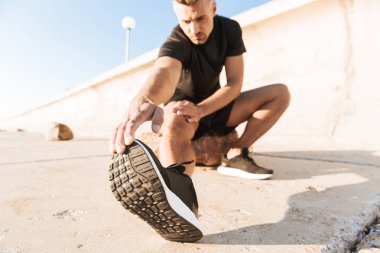 Sabah deniz kenarında germe egzersizleri yapıyor motive sporcu portresi