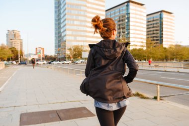 Açık havada çalışan sokakta inanılmaz genç spor kadının fotoğrafını görünümü geri.