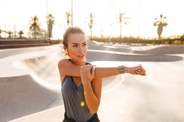 Şaşırtıcı spor kadın fotoğraf olun germe egzersizleri açık havada sokakta.