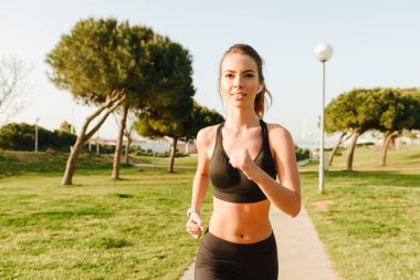 Fotoğraf şaşırtıcı genç kadın açık havada park müzik dinleme çimenlerde earphones ile çalışan spor.