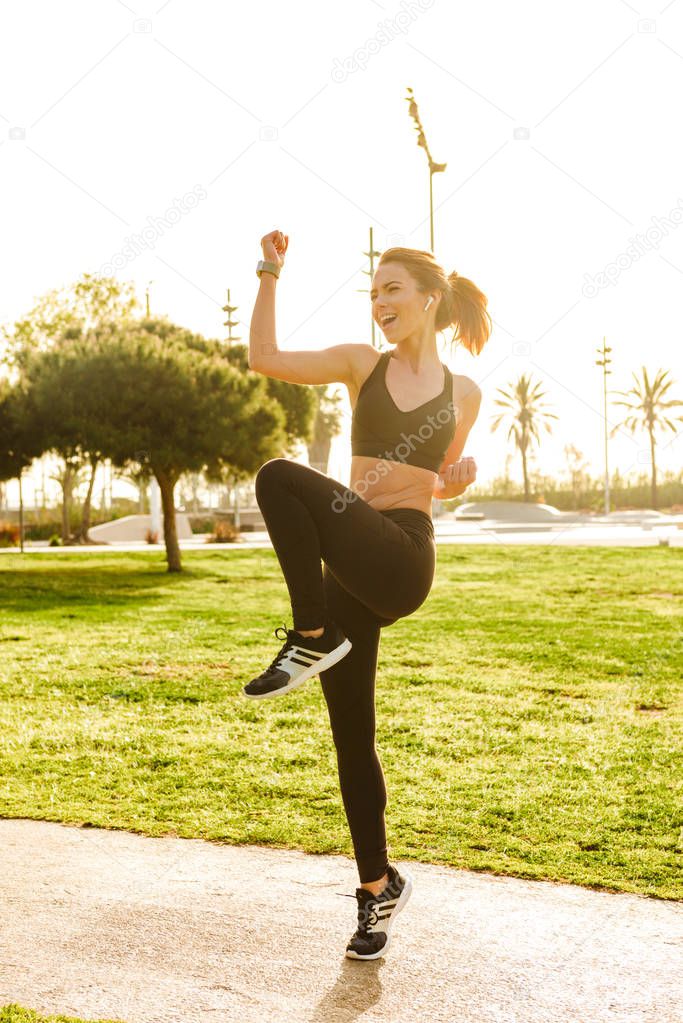 Image of gorgeous beautiful young sports woman make sport exercises outdoors.