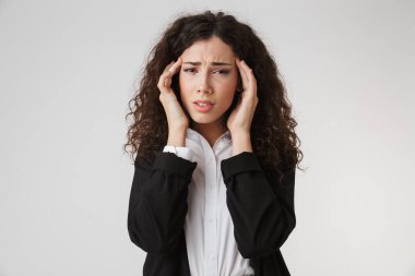 Üzgün memnun genç iş kadını izole kamera seyir beyaz duvar artalan üzerinde baş ağrısı ile görüntü.