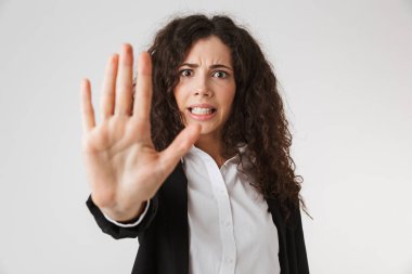 Beyaz arka plan üzerinde izole avucunun ile stop jest gösteren ciddi genç iş kadını portresi