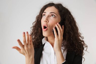 Cep telefonu beyaz arka plan üzerinde izole konuşurken bir şok genç iş kadını portresi