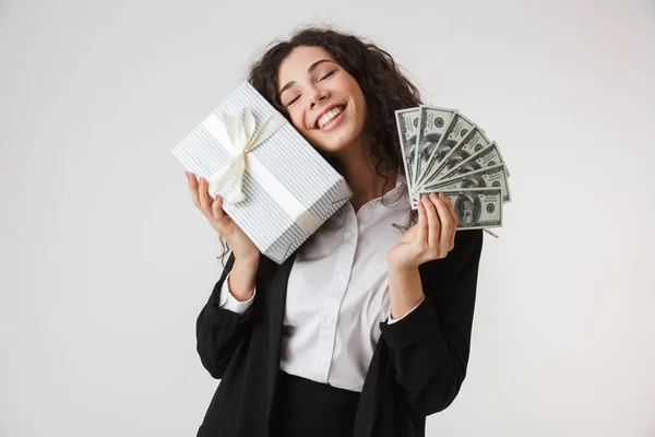 一个满意的年轻女商人的肖像持有目前的盒子和钞票孤立的白色背景 — 图库照片