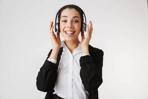 兴奋的情绪年轻的商业妇女的照片在白墙后台的耳机上收听音乐 — 图库照片