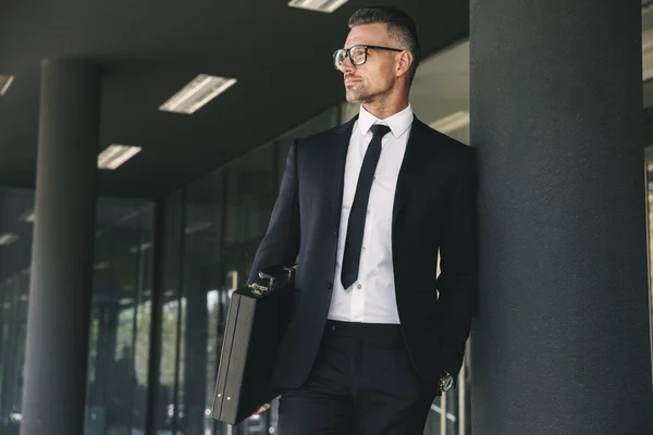 Portrait Handsome Young Businessman Dressed Suit Briefcase Standing Glass Building — Stock Photo, Image