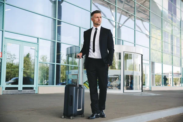 Vertrouwen Rijpe Zakenman Permanent Buiten Luchthaven Met Een Koffer — Stockfoto