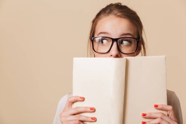 Yüzünü ve uzak izole bej renkli arka plan üzerinde seyir defteri tutan Eyewear bir genç kız portresi