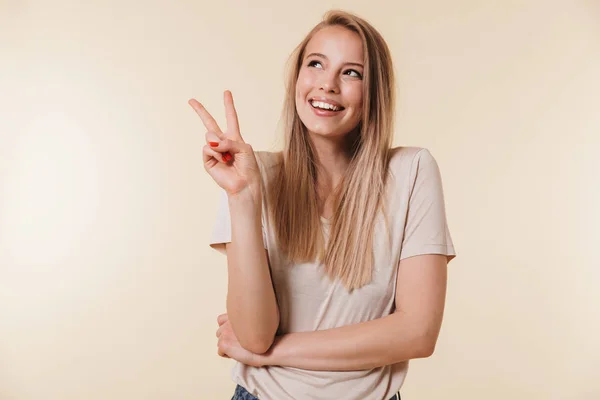 Portrait Smiling Casual Girl Showing Peace Gesture Isolated Beige Background — Stock Photo, Image
