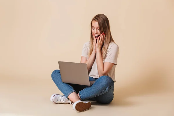 Portret Podekscytowany Dorywczo Dziewczynka Patrząc Laptopa Siedząc Podłodze Nogami Skrzyżowanymi — Zdjęcie stockowe