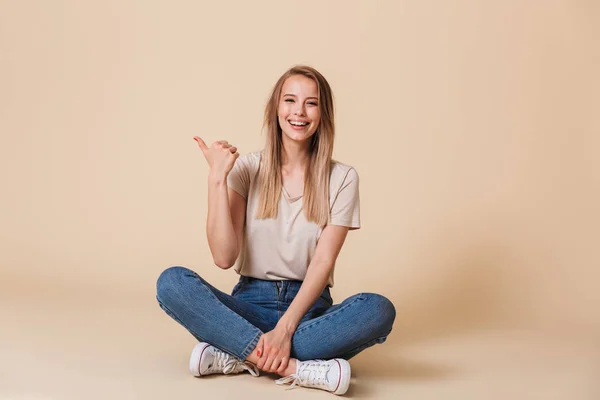 Foto Una Hermosa Mujer Señalando Con Dedo Lado Copyspace Mientras — Foto de Stock