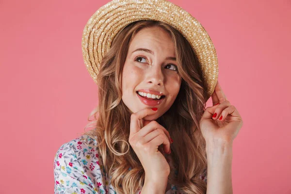 夏のドレスで笑顔の若い女性の肖像画間近し ピンク背景に分離麦わら帽子探して離れて — ストック写真