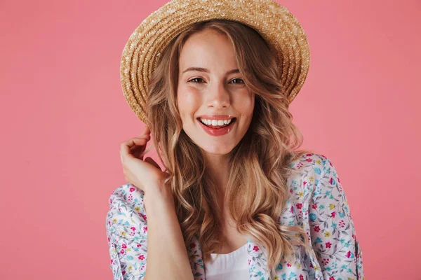 夏のドレスと麦わら帽子ピンク背景に分離カメラ目線で笑っている若い女性の肖像画間近します — ストック写真