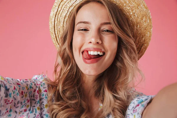 关闭在夏季礼服和草帽的一个快乐的年轻女子的肖像在粉红色背景自拍隔离 — 图库照片