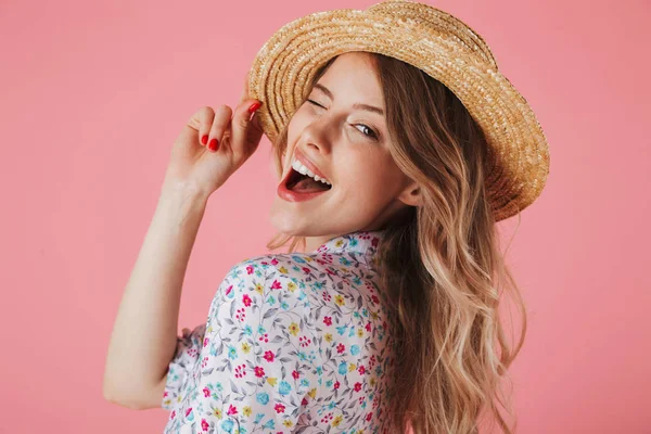 夏のドレスと麦わら帽子とピンクの背景に分離カメラ目線 ポーズでうれしそうな若い女性の肖像画間近します — ストック写真