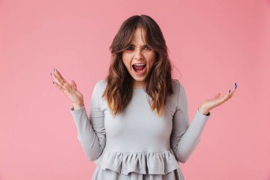 Görüntü izole kamera seyir pembe duvar arka plan üzerinde duran saldırgan genç güzel kadın çığlık.