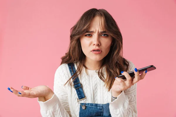 Portrait Confused Young Girl Holding Mobile Phone Isolated Pink Background — Stock Photo, Image