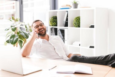 Formal giyim ve gözlük ofiste paket servisi olan restoran kahve yudumlarken siyah smartphone üzerinde konuşmak mutlu adam görüntüsünü