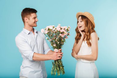 Görüntü mutlu beyaz gençler adamın karısı üzerinde mavi arka plan izole bir çiçek sağlar.