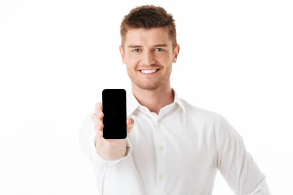 空白の画面携帯電話白背景に分離を示す笑みを浮かべて若い男の肖像 — ストック写真