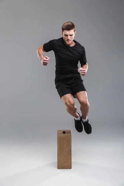 Полнометражный Портрет Мотивированного Молодого Спортсмена Прыгающего Через Деревянную Коробку Сером — стоковое фото