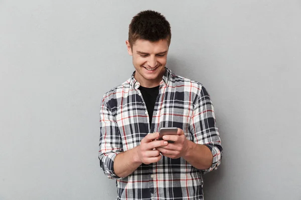 Retrato Joven Sonriente Usando Teléfono Móvil Sobre Fondo Gris — Foto de Stock