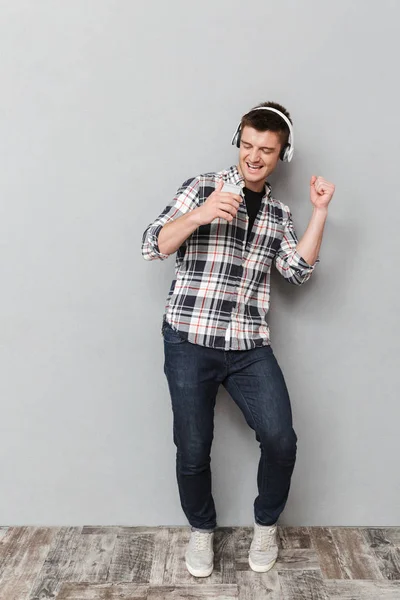 Full Length Portrait Happy Young Man Listening Music Headphones Holding — Stock Photo, Image