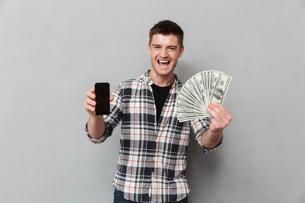 Retrato Joven Emocionado Mostrando Billetes Dinero Teléfono Móvil Blanco Sobre — Foto de Stock