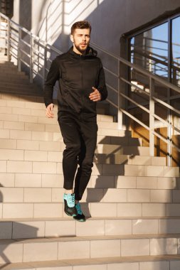 Açık havada adımlar üzerinde yapıyor ciddi genç sporcu portresi