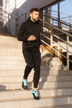 Açık havada adımlar üzerinde yapıyor konsantre genç sporcu portresi