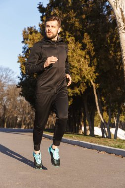 Kulaklıklar açık havada koşu ciddi genç sporcu portresi