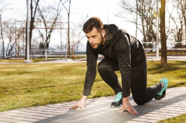 Kulaklıklar açık havada bir parkta çalıştırmak getting içinde kendine güvenen genç sporcu portresi