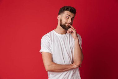 Görüntü izole kırmızı duvar arka plan üzerinde duran genç yakışıklı adam. Bir kenara arıyorsunuz.