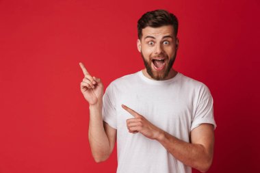 Yakışıklı genç duygusal adam arka plan kırmızı duvar işaret içinde izole ayakta görüntüsü. Görünümlü kamera.