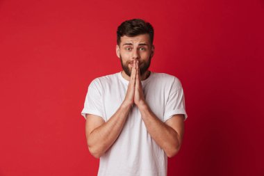 Kırmızı duvar arka plan üzerinde izole ayakta umutlu genç adam resmini yapmak lütfen hareket umut.