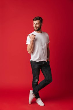 Fotoğraf arka plan kırmızı duvar işaret içinde izole ayakta çekici genç yakışıklı adam. Bir kenara arıyorsunuz.