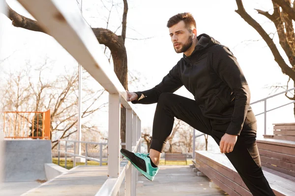 Retrato Jovem Desportista Confiante Fones Ouvido Fazendo Exercícios Alongamento Passos — Fotografia de Stock