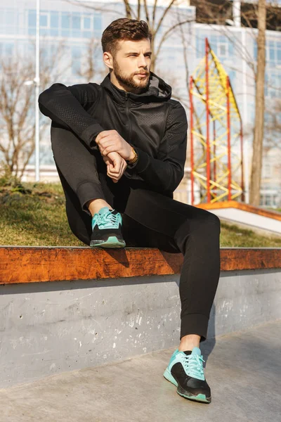 Retrato Joven Deportista Auriculares Descansando Mientras Está Sentado Afuera — Foto de Stock