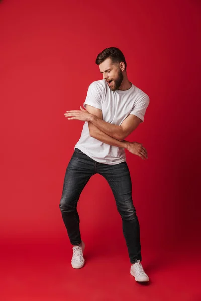 Foto Van Knappe Jonge Man Dansen Geïsoleerd Rode Muur Achtergrond — Stockfoto