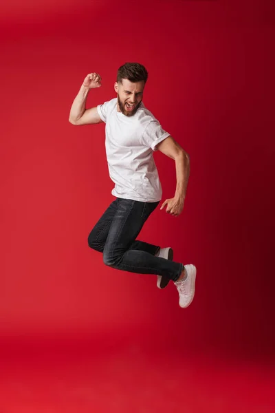 Foto Joven Guapo Saltando Aislado Sobre Fondo Pared Roja Mostrando — Foto de Stock