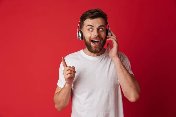 Photo Handsome Excited Young Man Isolated Red Wall Background Listening — Stock Photo, Image