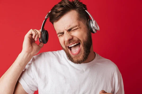 Elszigetelt Hallgató Piros Fal Háttérzene Fejhallgató Érzelmi Sikoltozó Fiatalember Képe — Stock Fotó