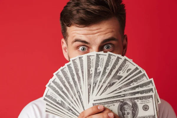 顔を覆っているお金を入れる赤い壁背景に分離された若い男のイメージ — ストック写真
