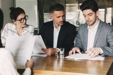 Bir grup resmi beyaz insan uygun Office masada oturan ve iş görüşmesi - iş, kariyer ve işe alım kavramı sırasında genç bayanla konuşmak